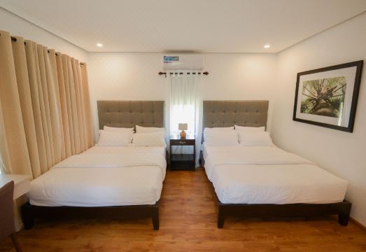 Casita room interior with two queen beds, hardwood floors, and warm lighting